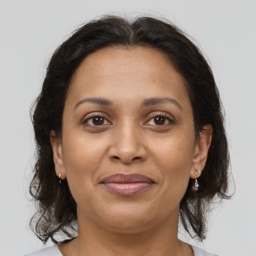 Joyful latino adult female with medium  brown hair and brown eyes