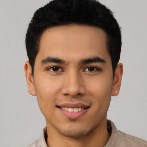 Joyful latino young-adult male with short  brown hair and brown eyes