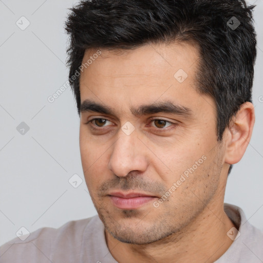 Joyful white young-adult male with short  black hair and brown eyes