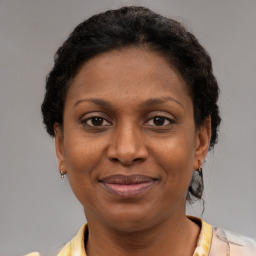 Joyful black adult female with short  brown hair and brown eyes