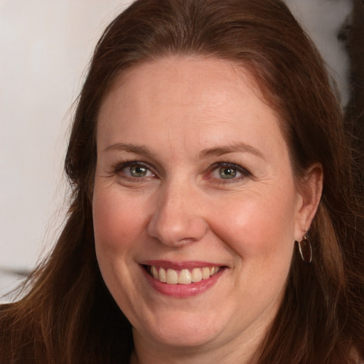 Joyful white adult female with long  brown hair and brown eyes