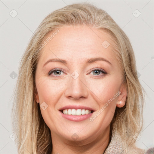 Joyful white adult female with long  brown hair and blue eyes