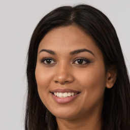 Joyful latino young-adult female with long  brown hair and brown eyes