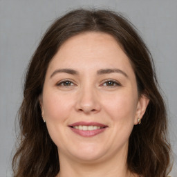 Joyful white adult female with long  brown hair and brown eyes