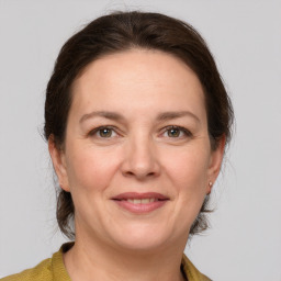 Joyful white adult female with medium  brown hair and grey eyes