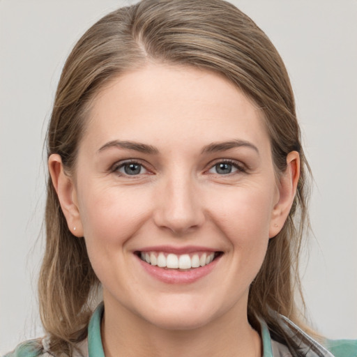 Joyful white young-adult female with medium  brown hair and grey eyes