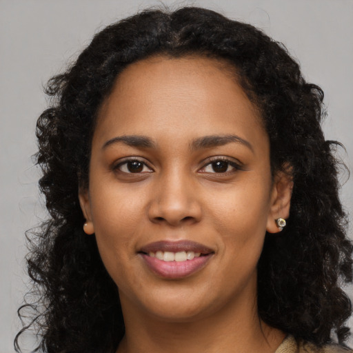 Joyful black young-adult female with long  brown hair and brown eyes