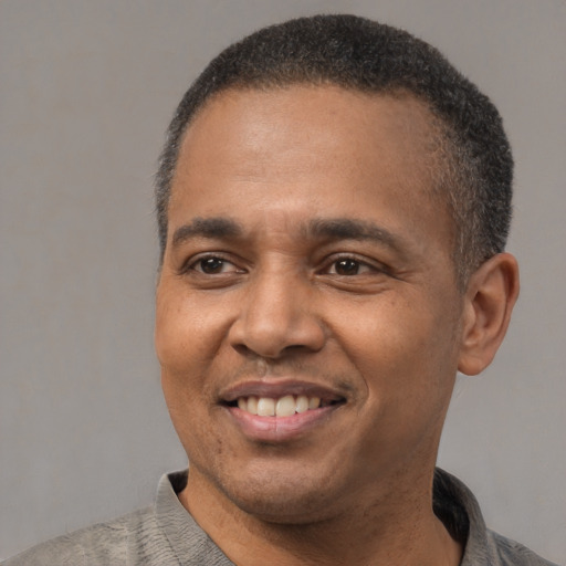 Joyful latino adult male with short  black hair and brown eyes