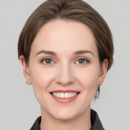 Joyful white young-adult female with medium  brown hair and grey eyes