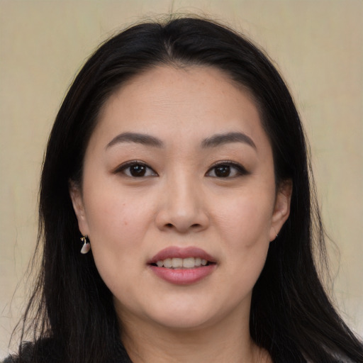 Joyful asian young-adult female with long  black hair and brown eyes