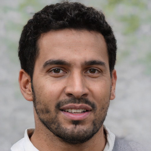 Joyful white young-adult male with short  black hair and brown eyes