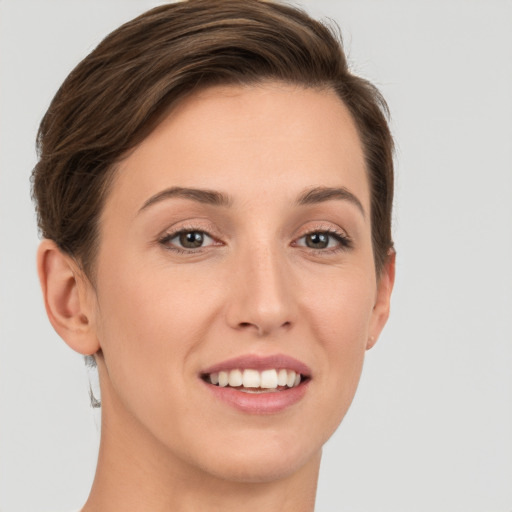 Joyful white young-adult female with short  brown hair and grey eyes