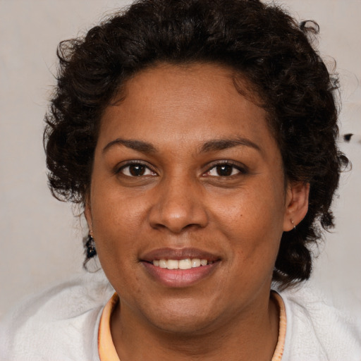 Joyful black young-adult female with medium  brown hair and brown eyes