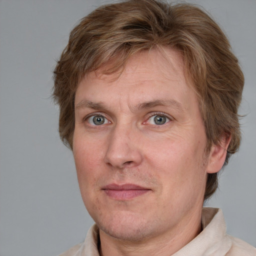 Joyful white adult male with short  brown hair and blue eyes