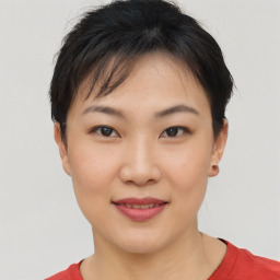 Joyful asian young-adult female with short  brown hair and brown eyes