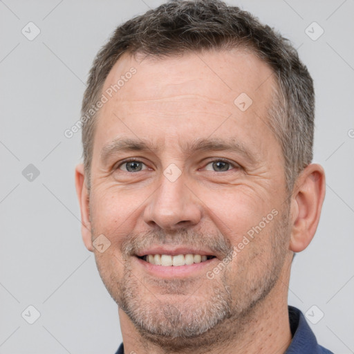 Joyful white adult male with short  brown hair and brown eyes