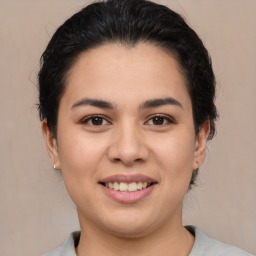 Joyful latino young-adult female with medium  brown hair and brown eyes