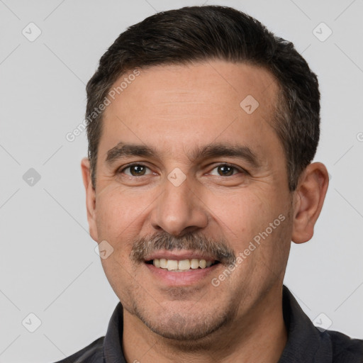 Joyful white young-adult male with short  black hair and brown eyes