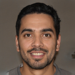 Joyful latino young-adult male with short  black hair and brown eyes