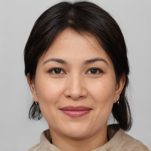 Joyful white adult female with medium  brown hair and brown eyes