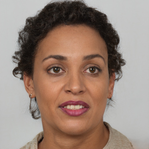 Joyful black adult female with short  brown hair and brown eyes