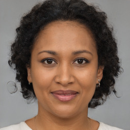 Joyful black adult female with medium  brown hair and brown eyes