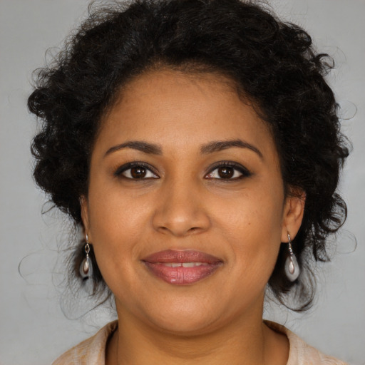 Joyful black young-adult female with long  brown hair and brown eyes