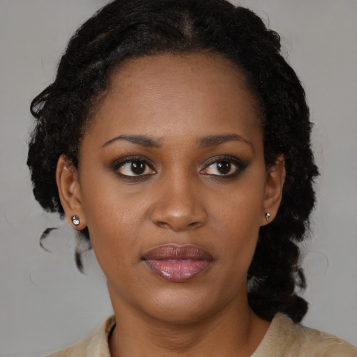 Joyful black young-adult female with medium  black hair and brown eyes