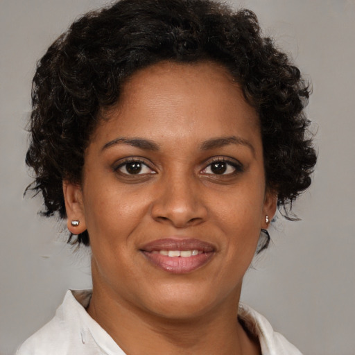 Joyful black young-adult female with short  brown hair and brown eyes