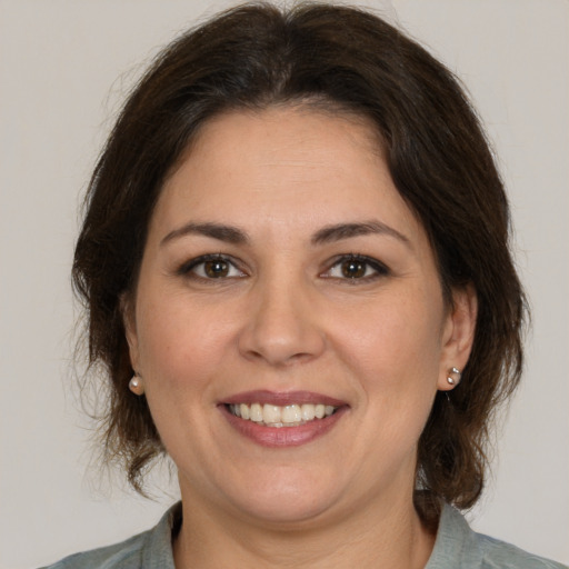 Joyful white adult female with medium  brown hair and brown eyes