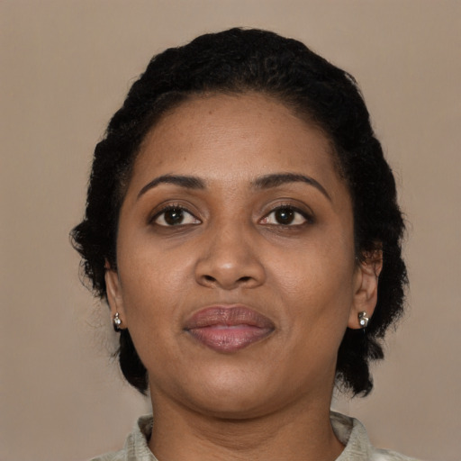 Joyful black adult female with short  black hair and brown eyes