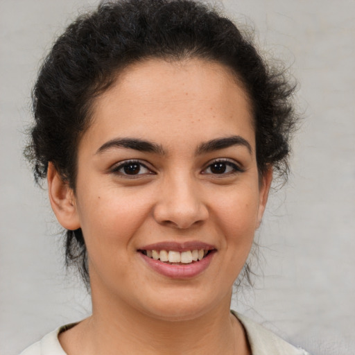 Joyful latino young-adult female with medium  brown hair and brown eyes