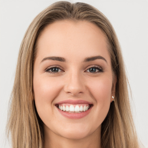 Joyful white young-adult female with long  brown hair and brown eyes