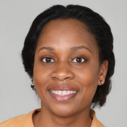 Joyful black adult female with medium  brown hair and brown eyes