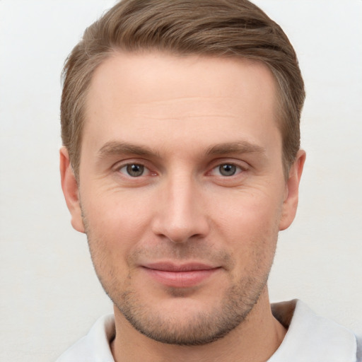 Joyful white young-adult male with short  brown hair and grey eyes