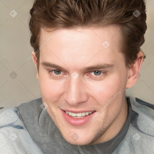 Joyful white young-adult male with short  brown hair and blue eyes