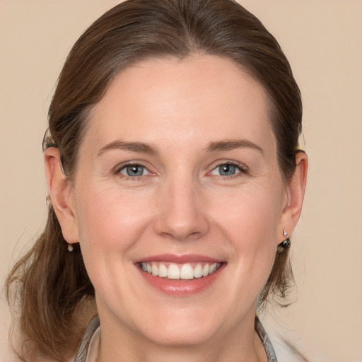 Joyful white adult female with medium  brown hair and grey eyes