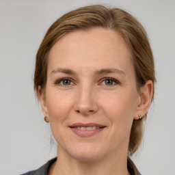 Joyful white adult female with medium  brown hair and grey eyes