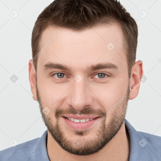 Joyful white young-adult male with short  brown hair and grey eyes