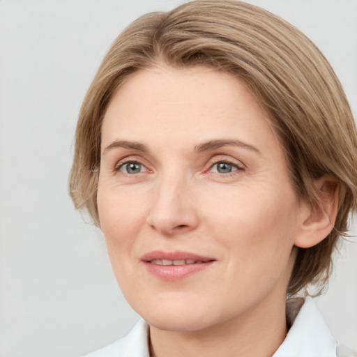 Joyful white adult female with medium  brown hair and grey eyes