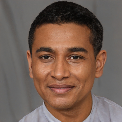 Joyful latino young-adult male with short  black hair and brown eyes