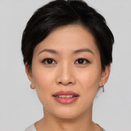 Joyful asian young-adult female with short  black hair and brown eyes