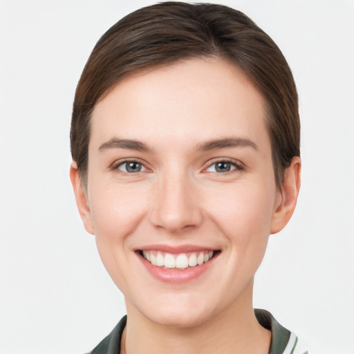 Joyful white young-adult female with short  brown hair and grey eyes