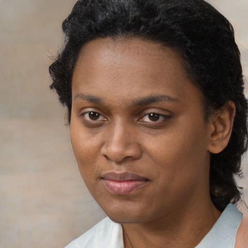 Joyful black young-adult female with short  black hair and brown eyes
