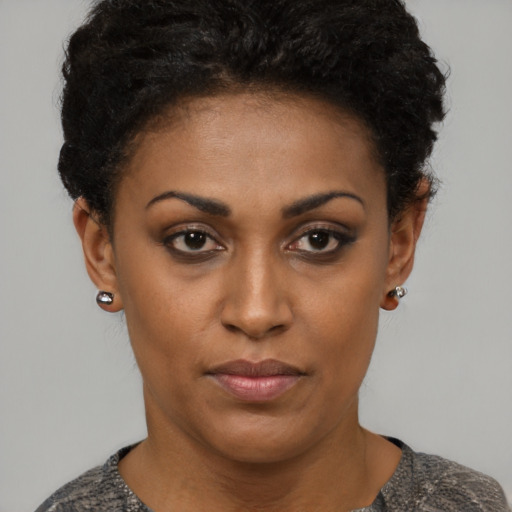 Joyful black young-adult female with short  black hair and brown eyes
