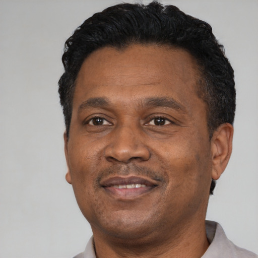 Joyful black adult male with short  black hair and brown eyes