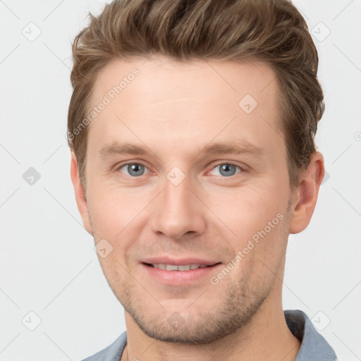 Joyful white young-adult male with short  brown hair and grey eyes