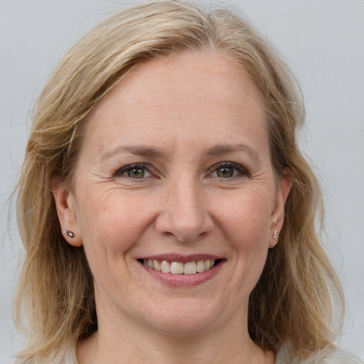 Joyful white adult female with medium  brown hair and grey eyes