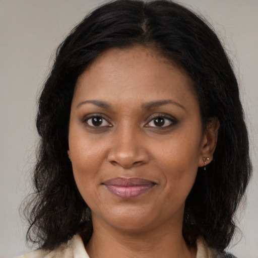 Joyful black adult female with long  brown hair and brown eyes