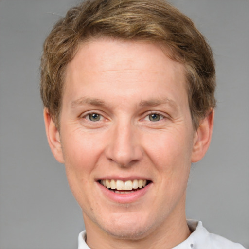 Joyful white adult male with short  brown hair and grey eyes